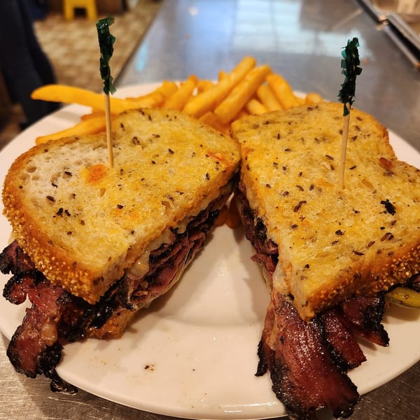 A Kountry Folks Homestyle Restaurant pastrami sandwich with fries on a white plate.