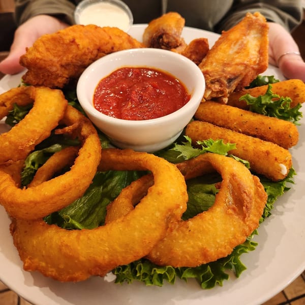A Kountry Folks Homestyle Restaurant platter with fried chicken, onion rings, mozzarella sticks, and dipping sauces.