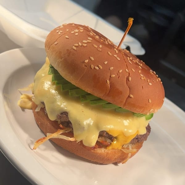 A Kountry Folks Homestyle Restaurant burger with melted cheese, avocado, and crispy onions.